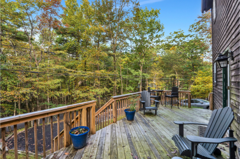 A deck with chairs and a railing in the woods AI-generated content may be incorrect., Picture