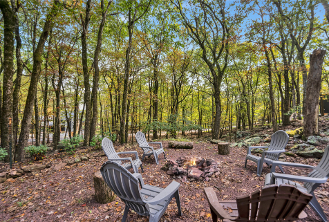 A group of chairs around a fire pit in a forest AI-generated content may be incorrect., Picture