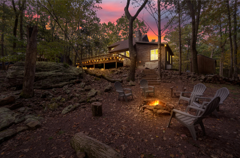 A house with a fire pit and chairs in the woods AI-generated content may be incorrect., Picture
