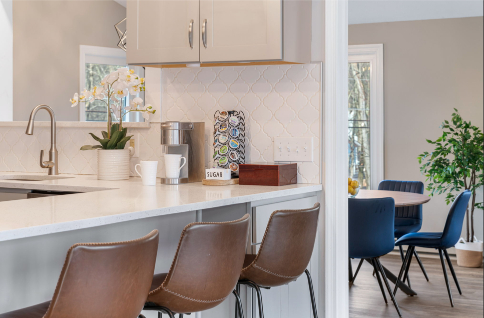 A kitchen with a white countertop and brown chairs AI-generated content may be incorrect., Picture